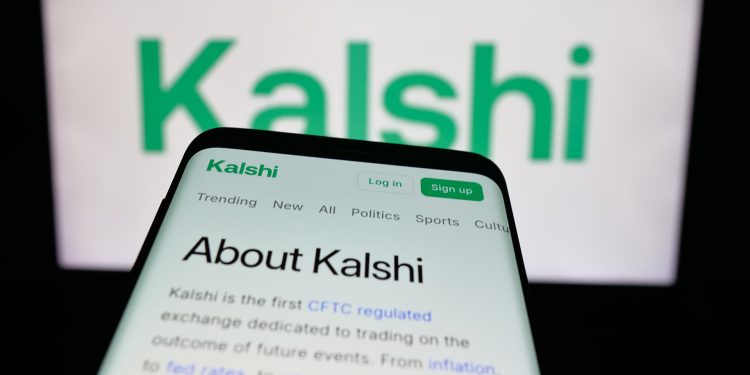Massachusetts Judge Moves to Block Kalshi Sports Contracts缩略图 Mobile phone with website of US prediction market company Kalshi Inc. on screen in front of logo. Focus on top-left of phone display.