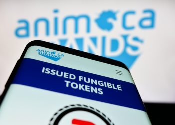 Mobile phone with webpage of software company Animoca Brands Corporation Ltd. on screen in front of logo. Focus on top-left of phone display.