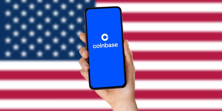 A hand holding a smartphone and the coinbase app logo. The USA flag in the background. coinbase Application Logo. Technology concept. Close up.