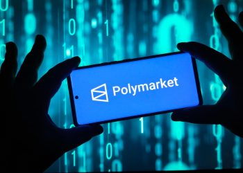 Hands holding smartphone with Polymarket logo on screen