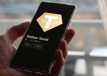 An investor analyzing the price of Tether Gold, the token coin $XAUT on a crypto exchange sreen.