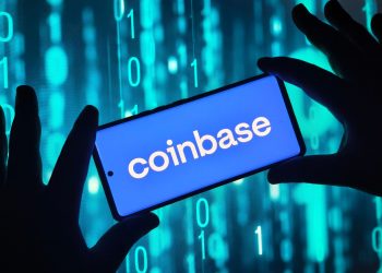 Hands holding smartphone with Coinbase app on screen